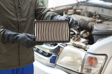 Closeup mechanic's hands hold air filter pad of car engine to check. Concept, car broken,repair and...