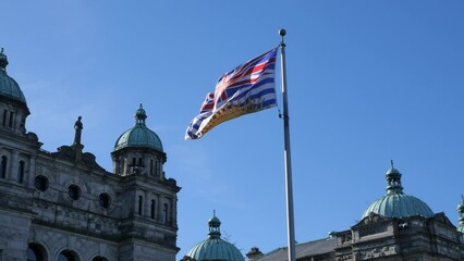 Flag of British Columbia waving in front of the Legislative Assembly of British Columbia Parliament Building in Victoria on Vancouver Island in Canada