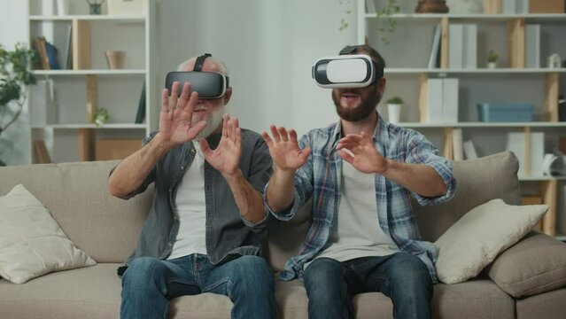 Young adult and senior immerse in VR gaming, exchanging experiences between generations through virtual reality, leveraging cutting-edge tech for entertainment, family teaching and understanding in VR