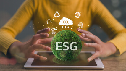 ESG environmental, social, and governance. Women hold the ESG icon on the green globe for the world...