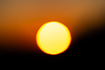 defocused blurred abstract shot of the sun setting behind a mountain