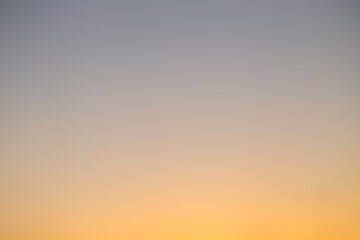 Abstract defocused shot of the sky during sunset hours casting a deep orange light
