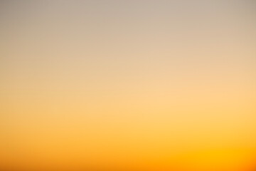 Abstract defocused shot of the sky during sunset hours casting a deep orange light