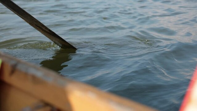 Closeup of a wooden paddle while sailing row boat in the river