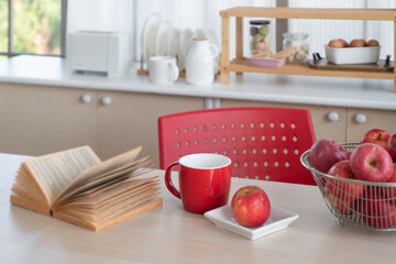 Fototapeta na wymiar Red apple and red cup place on table in kitchen, prepare breakfast on the kitchen table, kitchen background