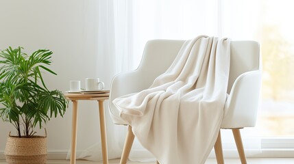 A white blanket draped over a single chair in a white living room used for mockup, brightly lit, 
