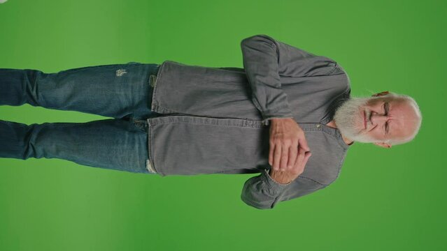 Vertical View.Green Screen.Portrait of an Old Man with a Heartache.An Elderly Man Feeling Sick, Having Painful Heart Feelings and and Gives Himself a Massage. Life After Illness.