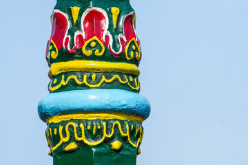 Javanese carving art on typical street lamp from Yogyakarta. Classic Javanese green framed lamp against bright blue sky background. Empty blank copy text space.