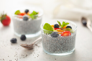 Chia puddind with fruit berry salad in bowl on grey background. Healthy breakfast