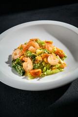 Shrimp salad with quinoa and mixed greens closeup, garnished with cherry tomatoes and a light dressing