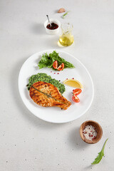 Seared salmon steak on a bed of spinach with a tasteful lemon wedge, ideal for healthy lifestyle and culinary presentations