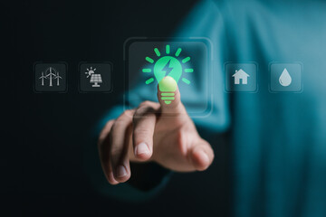 Sustainable energy concept. Person touching virtual green light bulb icon for sustainable energy at...