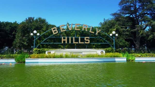 Beverly Hills, California, United States &ndash; April 16, 2019: Beverly Hills main city sign. Beverly Hills landmark and lake with sunlight reflection. City name at Beverly Gardens Park.