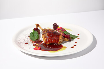 Duck leg confit with berry sauce, artistically presented on an isolated white background, a feast for the senses