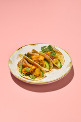Gluten-free tacos with sweet potato mousse and turkey on a vintage plate with pink background