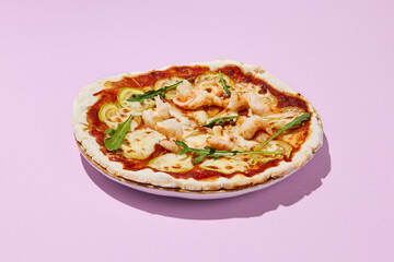 Gluten-free pizza with shrimp and zucchini on a pink background