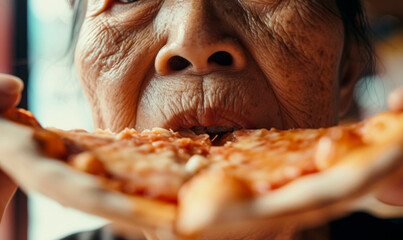 Macro shot of elderly Asian woman mouth biting a slice of pizza