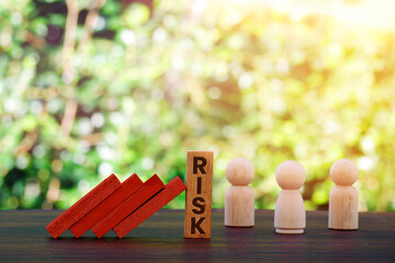 Risk word on wooden blocks, domino crisis effect. Financial, Economic, Business, Valuation,...