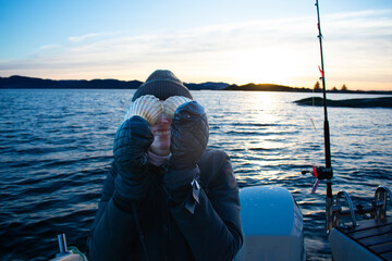 Female with seashell eyes on recreational motorboat in Norway Fjords.  Diving for scallops