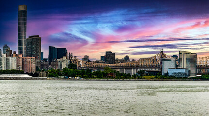 The Manhattan skyline and bridge at sunrise from Long Island which is an island that extends across...