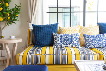 Mediterranean living room interior with bright yellow and blue sofa and pillow. Modern decor living room with carpet.