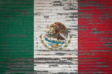 Close-up of old metal wall with national flag of Mexico. Concept of Mexico  export-import, storage of goods and national delivery of goods. Flag in grunge style