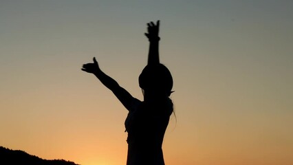 Silhouette footage of a woman happy relax turn around himself on sunset time, freedom and happiness concept
