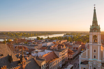 Fototapeta na wymiar Aerial panoramic view of historical buildings and roofs in Polish medieval town Torun at sunset