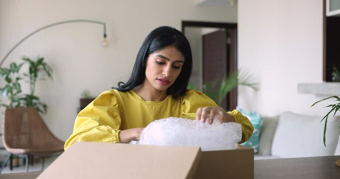 Indian woman got parcel with damaged items. Female open received package box with ordered goods feels frustrated, wrong not meeting expectations. E-commerce, replace, refund, cancel, negative feedback