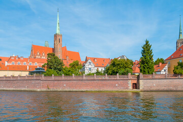 A view of Ostrów Tumski in Wrocław on a sunny day. In the background, you can see the Cathedral of St. John the Baptist.