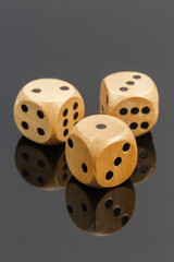 Three dice on a dark background with reflection