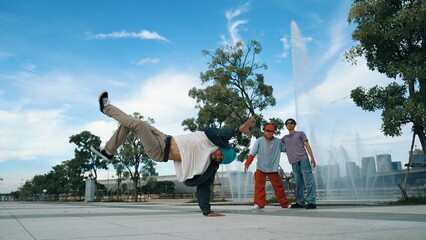 Professional attractive hipster perform street dance with fountain. Panorama shot of attractive...