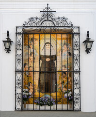 Ventana enrejada decorada hermosamente con azulejos mostrando a una monja en la fachada del...