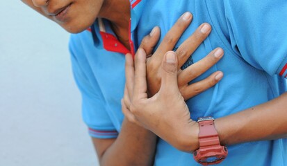 hand hold chest with heart attack symptoms, asian man have chest pain caused by heart disease,...