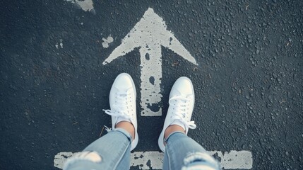 Make decision which way to go. Walking on directional sign on asphalt road. Female legs wearing jeans and white sneakers. - obrazy, fototapety, plakaty