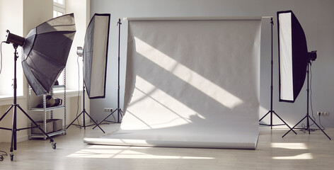 Studio for photo sessions. Professional photographer's work place. Sunny workspace interior with...