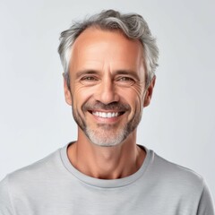 Portrait of a happy middle aged white man with grey hair. Closeup face of a handsome middle-aged man smiling at camera on white background. Front view, happy handsome man in white shirt looking camera
