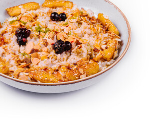 Muesli with dried fruits and milk in ceramic bowl