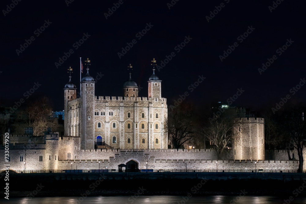 Wall mural Tower of London by the River Thames in London, UK, Lit up at Night