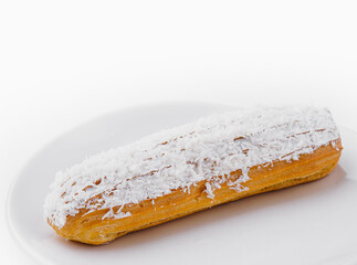 eclair in white glaze and coconut flakes