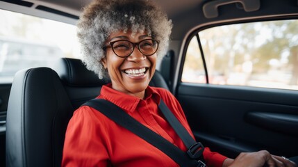 Portrait of a contented happy African American senior woman driving her new car.