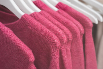 closeup of colorful woolen pullover on hangers in a woman fashion store showroom - 733021945
