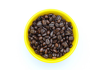 Roasted coffee beans in a bowl on white background top view 