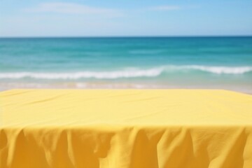 Fototapeta na wymiar empty yellow tablecloth on the table on the beach