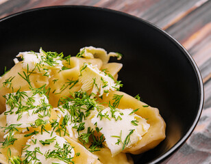Dumplings filled with mashed potato on black bowl