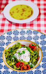 Plate of delicious pasta with pesto sauce on table