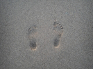 Fototapeta na wymiar Huellas de los pies en la arena
