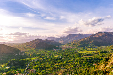 Naklejka premium amazing highland view from above to a canyon and valley between mountains and green hills, cloudy sunset landscape of beautiful highland