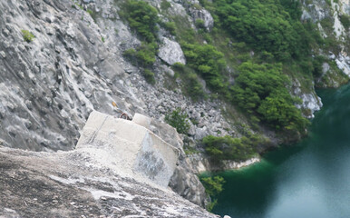 Concrete anchored retaining walls installed on rock cliff.