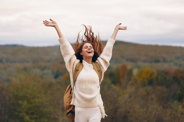 Smiling Woman Adventuring on Mountain Cliff with Backpack: A Stylish Journey to Freedom